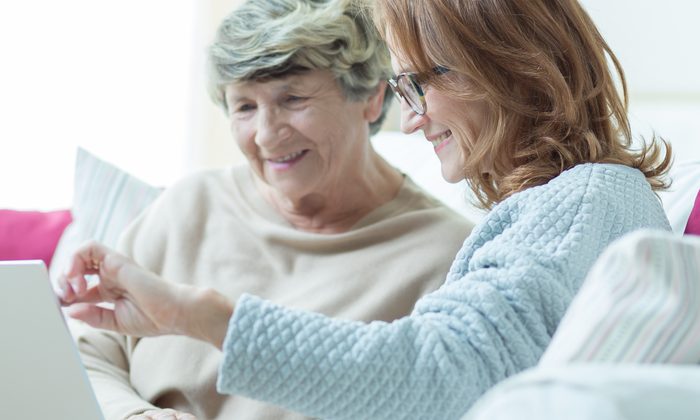 Zwei Frauen sitzen gemeinsam auf dem Sofa