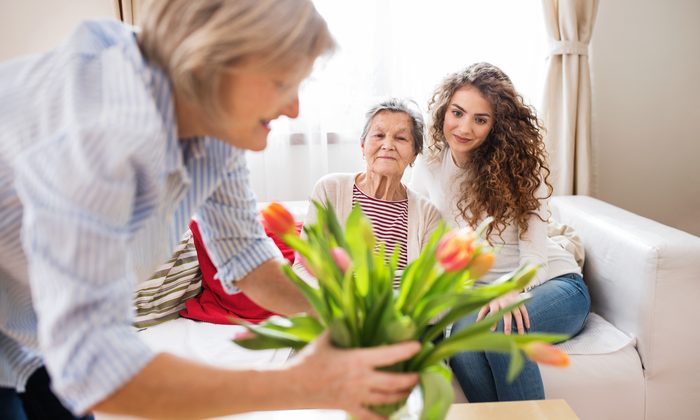 Betreuerin bringt Blumen ins Wohnzimmer
